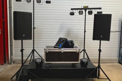 Salle de réception avec éclairage coloré, tables hautes et écran de projection au fond.