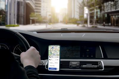 Une femme en tenue professionnelle sort d'une voiture noire, accueillie par un chauffeur en costume.