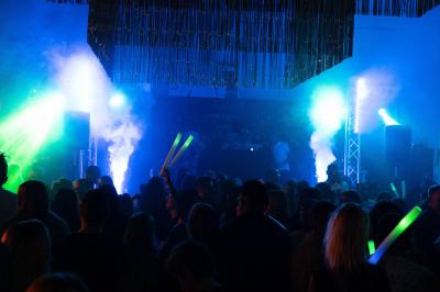 Salle de détente avec fauteuils variés, table basse, tapis géométrique et éclairage tamisé.