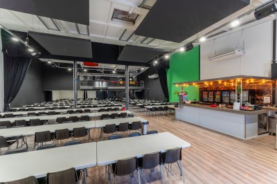 Salle de détente avec fauteuils variés, table basse, tapis géométrique et éclairage tamisé.