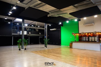 Salle de détente avec fauteuils variés, table basse, tapis géométrique et éclairage tamisé.
