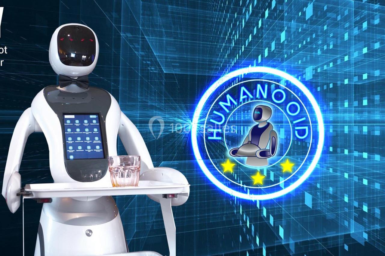 Un robot humanoïde avec un écran tactile et un plateau, devant un fond numérique avec un logo ’Humanoid’.