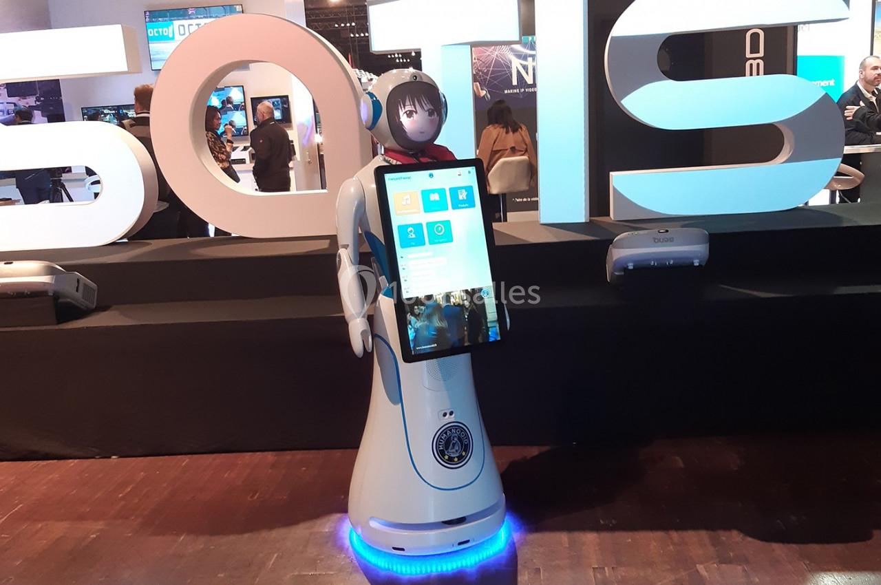 Un robot humanoïde équipé d'un écran tactile, exposé dans un salon technologique.