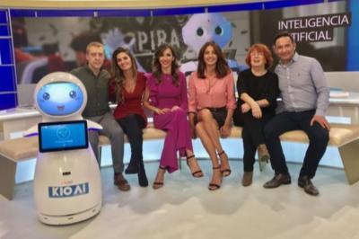 Robot humanoïde blanc équipé d'un écran et d'un plateau, présenté dans un environnement intérieur avec plantes et…