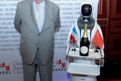 Robot humanoïde blanc équipé d'un écran et d'un plateau, présenté dans un environnement intérieur avec plantes et…