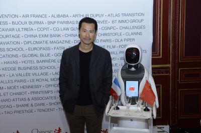 Robot humanoïde blanc équipé d'un écran et d'un plateau, présenté dans un environnement intérieur avec plantes et…