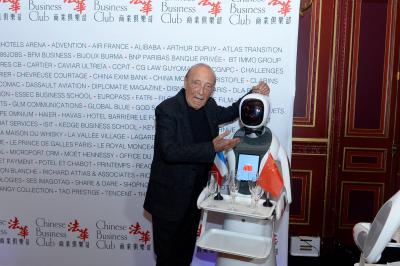 Robot humanoïde blanc équipé d'un écran et d'un plateau, présenté dans un environnement intérieur avec plantes et…