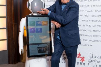 Robot humanoïde blanc équipé d'un écran et d'un plateau, présenté dans un environnement intérieur avec plantes et…