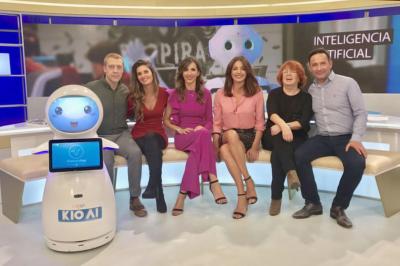 Robot humanoïde blanc équipé d'un écran et d'un plateau, présenté dans un environnement intérieur avec plantes et…