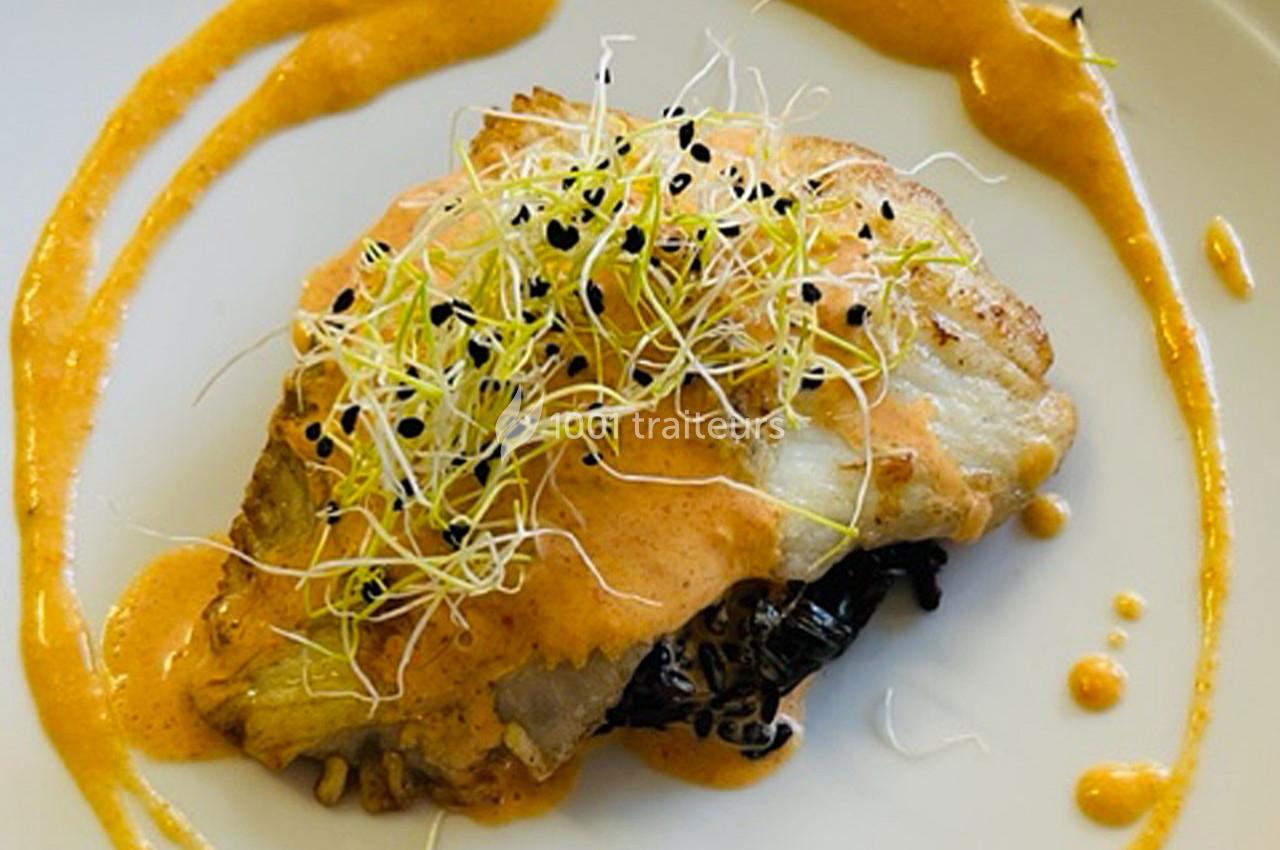 Filet de poisson grillé nappé de sauce orange, garni de pousses germées et servi sur un lit de légumes.