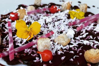 Miniature Traiteur Brebières (Pas-de-Calais) - Maison Lh Traiteur #13 Assiette de légumes rôtis avec pommes de terre violettes, garnie de pousses fraîches et de fleurs comestibles.