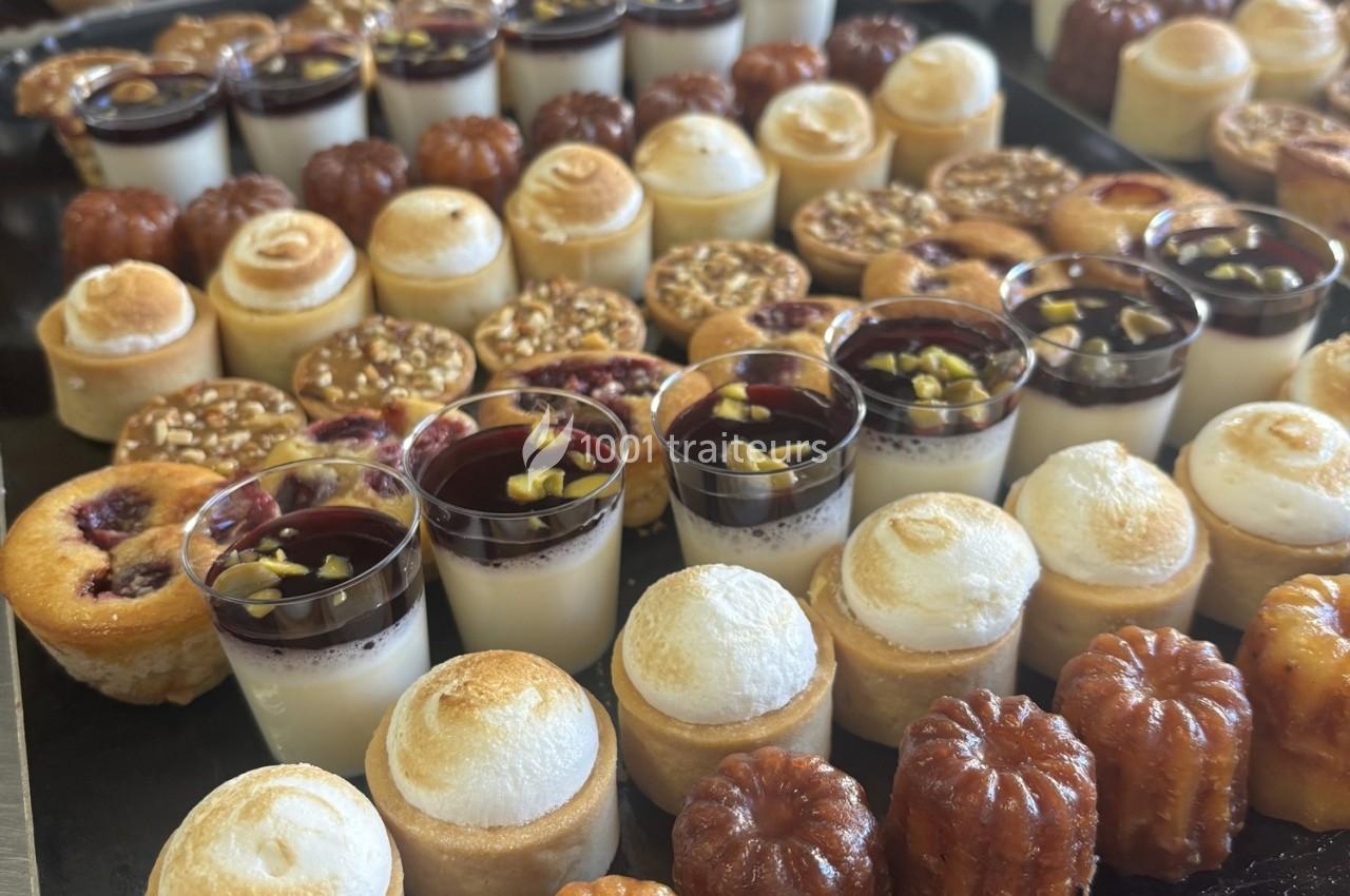 Plateau de desserts variés comprenant cannelés, verrines, tartelettes et autres pâtisseries miniatures.