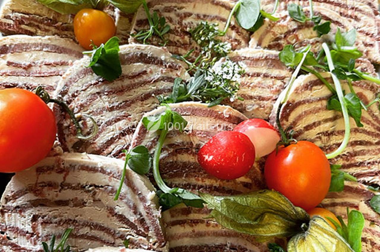 Tranches de terrine marbrée garnies de tomates cerises, radis et herbes fraîches.