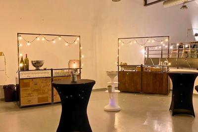 Intérieur d'un grand espace industriel lumineux avec sol clair, murs blancs, poutres métalliques et conduits apparents.