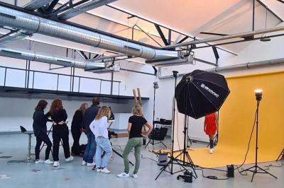 Intérieur d'un grand espace industriel lumineux avec sol clair, murs blancs, poutres métalliques et conduits apparents.