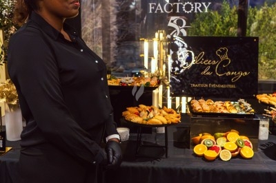 Buffet avec plats variés, incluant viandes grillées garnies de citron et légumes frais en présentation colorée.