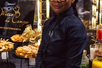 Buffet avec plats variés, incluant viandes grillées garnies de citron et légumes frais en présentation colorée.