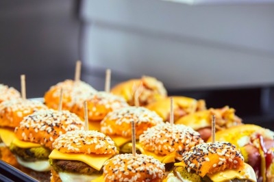 Buffet avec plats variés, incluant viandes grillées garnies de citron et légumes frais en présentation colorée.