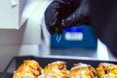 Buffet avec plats variés, incluant viandes grillées garnies de citron et légumes frais en présentation colorée.