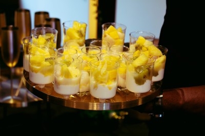 Buffet avec plats variés, incluant viandes grillées garnies de citron et légumes frais en présentation colorée.