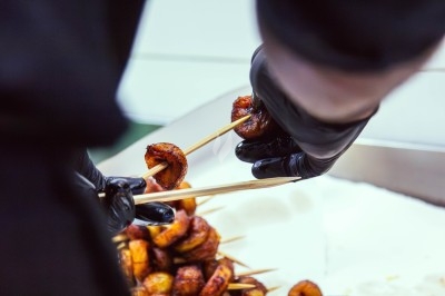 Buffet avec plats variés, incluant viandes grillées garnies de citron et légumes frais en présentation colorée.
