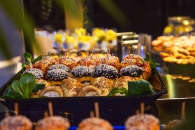 Buffet avec plats variés, incluant viandes grillées garnies de citron et légumes frais en présentation colorée.