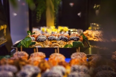 Buffet avec plats variés, incluant viandes grillées garnies de citron et légumes frais en présentation colorée.