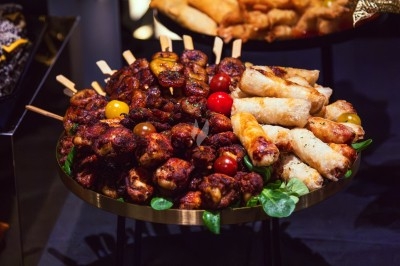 Buffet avec plats variés, incluant viandes grillées garnies de citron et légumes frais en présentation colorée.
