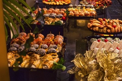 Buffet avec plats variés, incluant viandes grillées garnies de citron et légumes frais en présentation colorée.