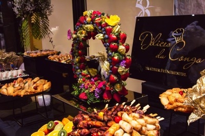 Buffet avec plats variés, incluant viandes grillées garnies de citron et légumes frais en présentation colorée.