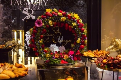 Buffet avec plats variés, incluant viandes grillées garnies de citron et légumes frais en présentation colorée.