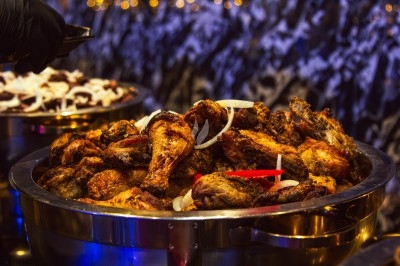 Buffet avec plats variés, incluant viandes grillées garnies de citron et légumes frais en présentation colorée.