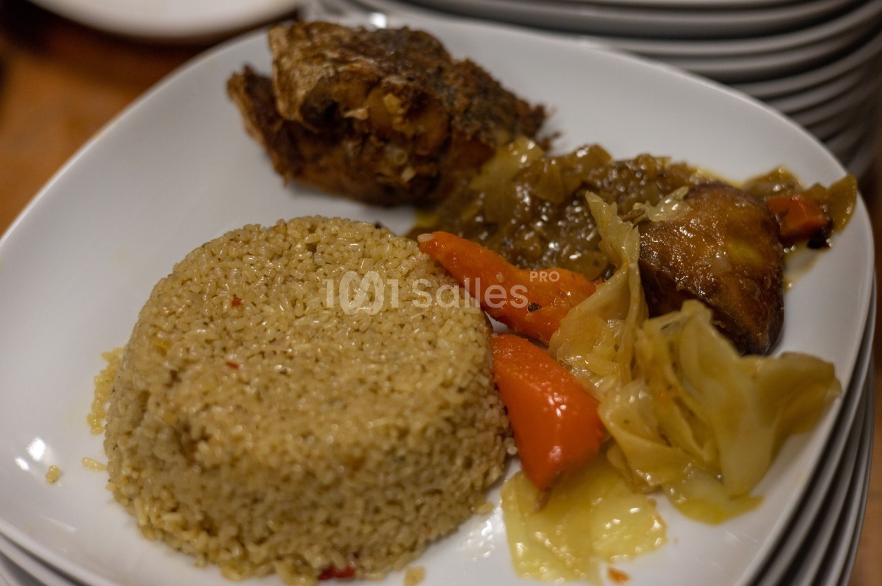 Assiette contenant du riz, des légumes braisés et un morceau de viande cuite, servie sur une table.