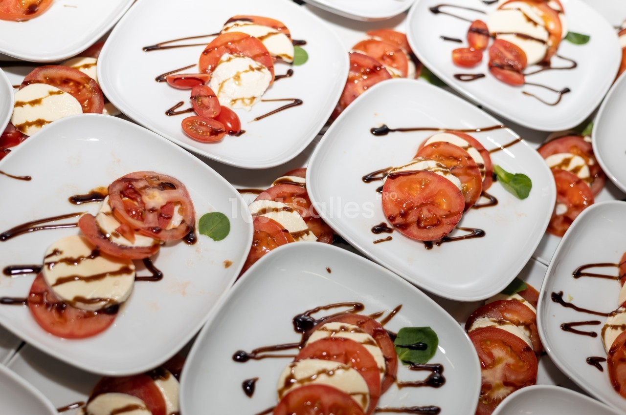 Assiettes de salade caprese avec tomates, mozzarella, feuilles de basilic et filet de vinaigre balsamique.