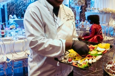 Miniature Traiteur Arpajon (Essonne) - Délices du Congo #46 Buffet varié avec plats de viande grillée, légumes frais et charcuterie, présenté dans des plats en métal.