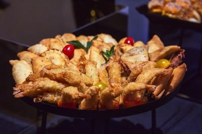 Miniature Traiteur Arpajon (Essonne) - Délices du Congo #67 Buffet varié avec plats de viande grillée, légumes frais et charcuterie, présenté dans des plats en métal.