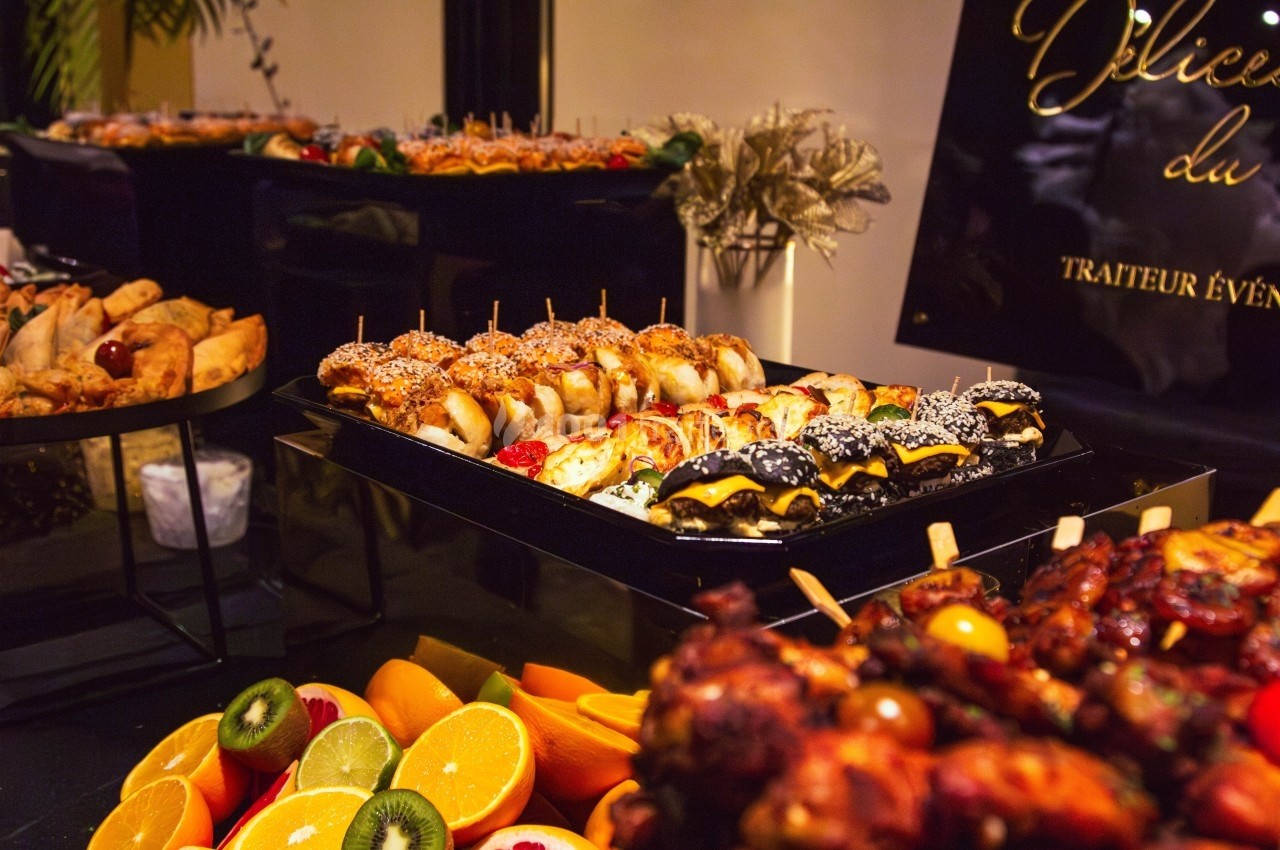 Buffet avec brochettes variées, fruits frais tranchés et autres amuse-bouches dans un cadre élégant.