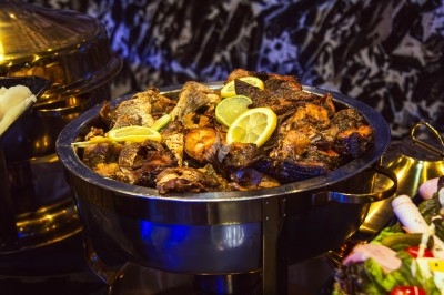 Miniature Traiteur Arpajon (Essonne) - Délices du Congo #94 Buffet varié avec plats de viande grillée, légumes frais et charcuterie, présenté dans des plats en métal.