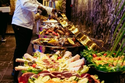 Miniature Traiteur Arpajon (Essonne) - Délices du Congo #96 Buffet varié avec plats de viande grillée, légumes frais et charcuterie, présenté dans des plats en métal.