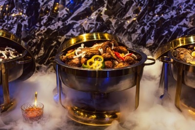 Miniature Traiteur Arpajon (Essonne) - Délices du Congo #100 Buffet varié avec plats de viande grillée, légumes frais et charcuterie, présenté dans des plats en métal.