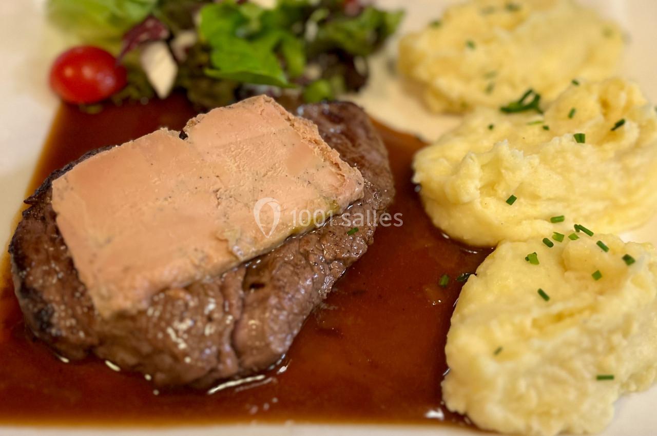 Plat composé d'un steak nappé de foie gras, accompagné de purée de pommes de terre et d'une salade verte.