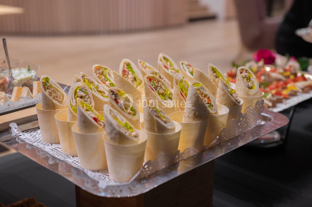Assortiment de wraps garnis présentés dans des cônes en bois sur un plateau décoré.