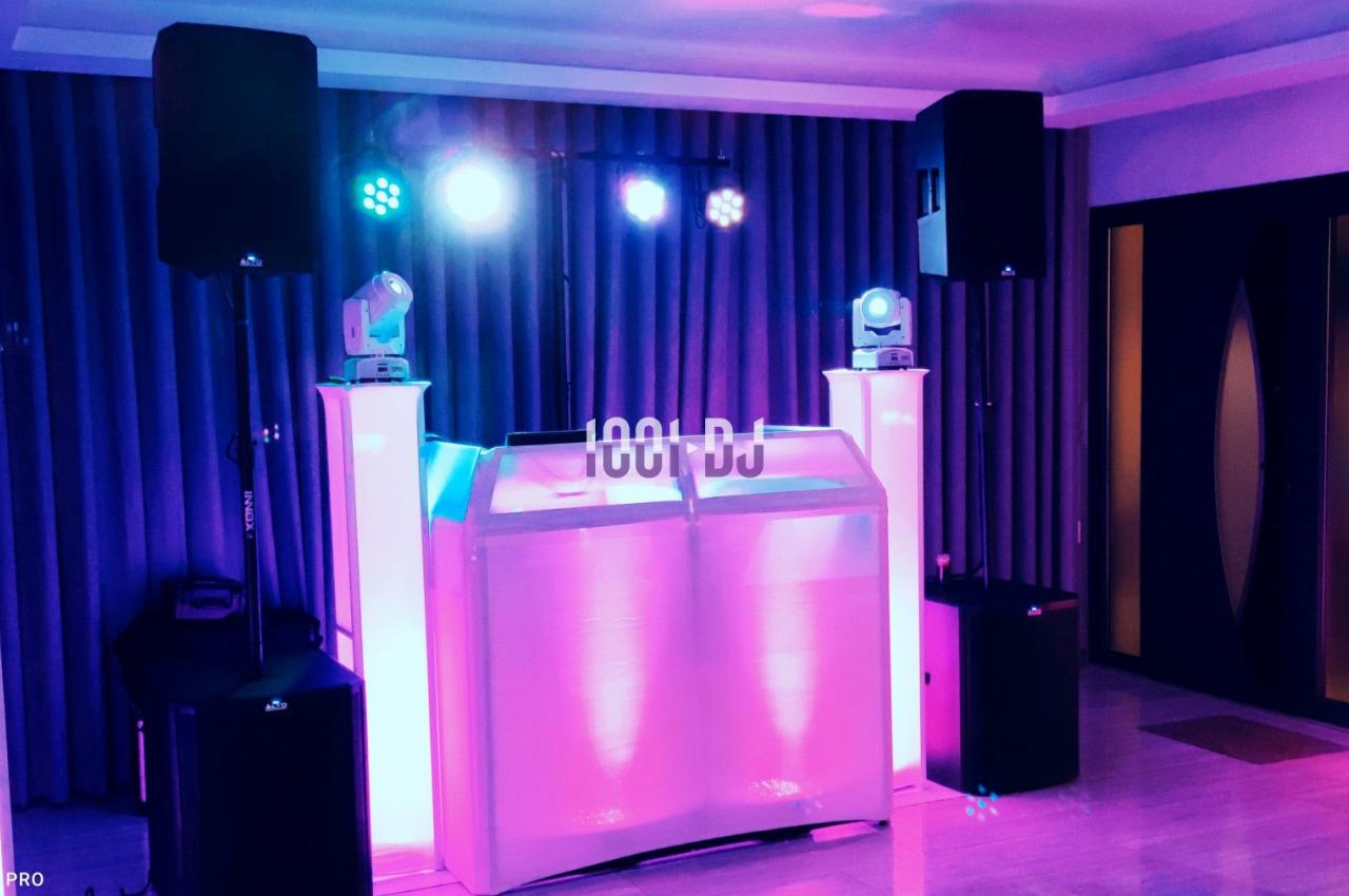 Installation de matériel de sonorisation et éclairage avec une table de DJ dans une salle intérieure.