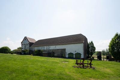 Salle lumineuse avec bar en bois, tables en verre, chaises noires et grandes fenêtres laissant entrer la lumière naturelle.