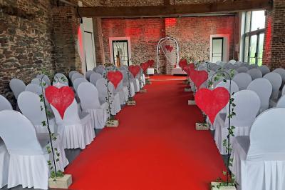 Salle lumineuse avec bar en bois, tables en verre, chaises noires et grandes fenêtres laissant entrer la lumière naturelle.