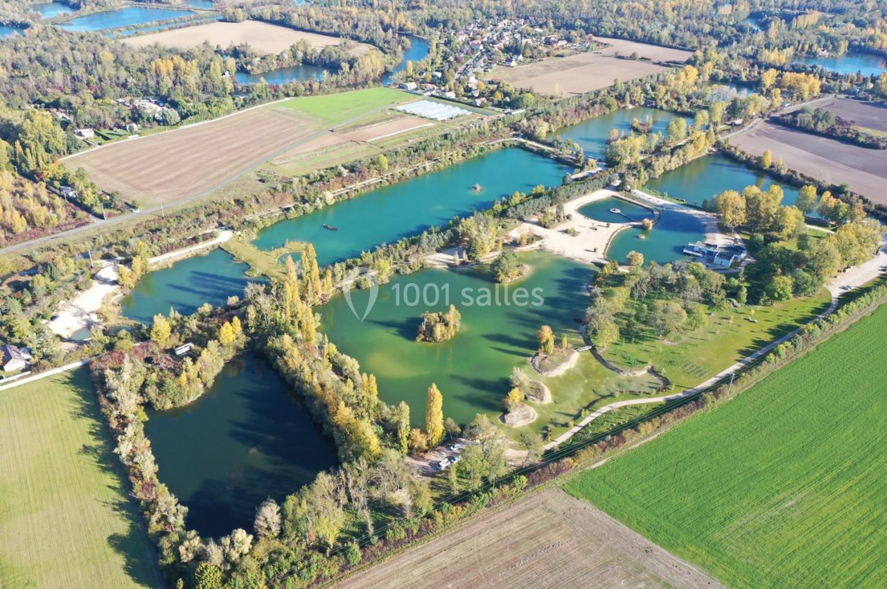 Vue aérienne d'un complexe de lacs entourés de champs, de forêts et de petites infrastructures.
