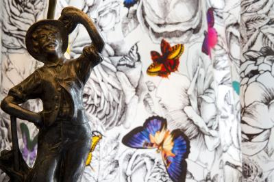 Deux chaises en bois et une table ronde avec un seau à glace sur une terrasse donnant sur un jardin verdoyant.