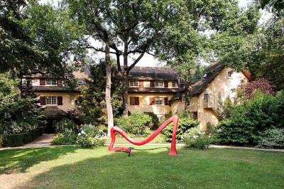 Deux chaises en bois et une table ronde avec un seau à glace sur une terrasse donnant sur un jardin verdoyant.