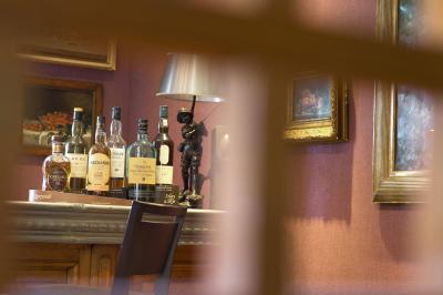 Deux chaises en bois et une table ronde avec un seau à glace sur une terrasse donnant sur un jardin verdoyant.