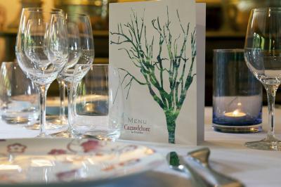 Deux chaises en bois et une table ronde avec un seau à glace sur une terrasse donnant sur un jardin verdoyant.
